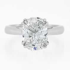 an oval cut diamond ring on a white background