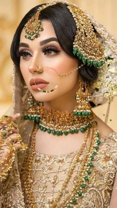 a woman in a bridal outfit with jewelry on her face