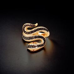 "Customizable Snake Ring in Cubic Zirconia, 10K 14K 18K Gold Options, Adjustable Women's Statement Jewelry" - Band Width: 3.90 mm - Weight: 4.00 gr   ✨  Elevate your style with our Customizable Snake Statement Ring, a bold and unique piece that captures attention! This striking ring is adorned with high-quality black zircon stones and is available in 10K, 14K, or 18K gold. Choose from white gold, rose gold, or yellow gold to perfectly match your taste. 🐍 Its adjustable design ensures a comfortable fit for any finger size, making it versatile for both everyday wear and special occasions.  💎 Featuring a powerful and elegant snake motif, this ring adds a touch of mystique and sophistication to your look. Each detail is meticulously crafted, and each stone is hand-set for maximum brilliance. Cubic Zirconia Rings With Black Diamonds As Gift, Black Diamond Rings For Party, Gold Ring With Black Diamonds, Black Diamond Party Ring, Black Diamonds Cubic Zirconia Rings As Gift, Gold Diamond Ring With Black Diamonds As Gift, Gold Diamond Ring With Black Diamonds For Gift, Black Cubic Zirconia Crystal Ring For Gift, Adjustable Unique Yellow Gold Snake Ring