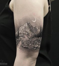 a woman with a mountain scene tattoo on her arm