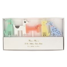 three candles in a white box with dogs on them and the words meri mee 5