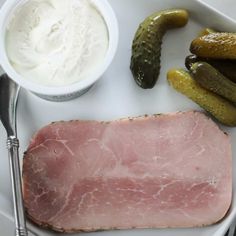 a white plate topped with meat and pickles