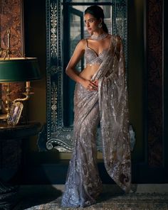 This steel grey net saree features sequin and crystal embroidery. The saree border is scalloped and is paired with crystal embedded blouse.From Seema Gujral's Kashish collection DELIVERY TIMEPlease allow 8-12 weeks for your outfit to arrive. FABRIC DETAILSNet Professional cleaning only. Grey Net Saree, Crystal Saree, Seema Gujral, Grey Saree, Sequin Saree, New Saree Blouse Designs, Indian Bride Outfits, Bollywood Dress, Crystal Embroidery