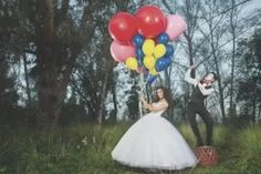 a bride and groom are holding balloons in the air