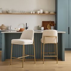 two white chairs sitting next to each other in a kitchen