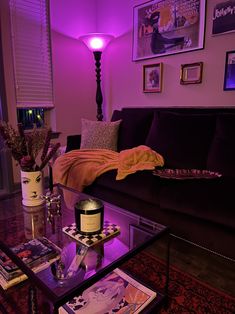 a living room filled with furniture and a purple light on the wall above it's coffee table