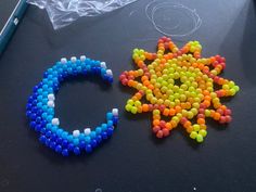 two bracelets made out of beads sitting next to each other on a black surface