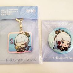 two keychains with anime characters on them sitting next to each other in plastic packaging