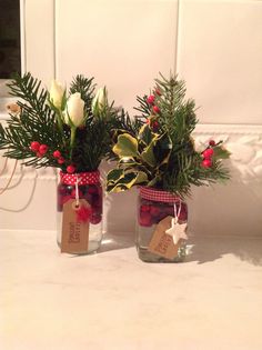 two vases filled with flowers sitting on top of a counter