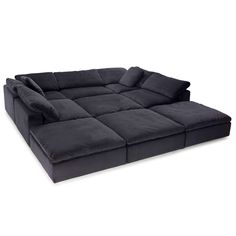 a large black couch with pillows on it's back and seat cushions in the middle