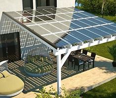 an image of a house with solar panels on the roof and patio furniture in the foreground