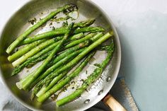 asparagus being cooked in a pan on a table