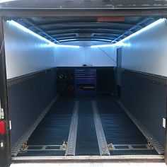 the back end of a truck with its doors open and lights shining on it's sides