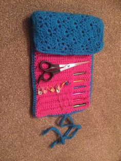 a pair of scissors and some crochet are laying on the floor next to a bag