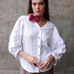 "Stylish Balloon Sleeve Linen Blouse with a modern oversized look. Featuring exaggerated puff sleeves, a V-neck design, and a comfortable ¾ sleeve length. Perfect to pair with simple bottoms for a chic and contemporary style. DETAILS ⚬ V-neckline. ⚬ Front button closure. ⚬ 3/4 puff sleeves. ⚬ Cocoon Back. ⚬ Made of washed organic Oeko-Tex certified linen. ⚬ The linen is NOT see-through. ⚬ Shown here in White.  FIT / SIZE ⚬ Designed for a loose fit.  If you would like to add or subtract 10cm from the length, let us know. ⚬ Handmade to order (can be made-to-measure, please write down your measurements in the personalization box) ⚬ Sizes XXS to XL (please see detailed size chart in photos). MODEL'S MEASUREMENTS ⚬ The model is wearing a size XS. ⚬ The model's measurements are Bust 34½\" (88 cm Oversized Look, Puff Sleeve Blouse, Linen Blouse, Linen Top, Style Chic, Balloon Sleeves, Natural Linen, Neck Designs, Womens Clothing Tops