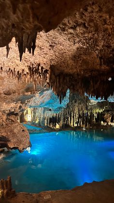 the inside of a cave with blue water