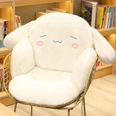 a white chair with a large stuffed animal on it's back in front of a bookshelf