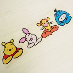 winnie the pooh and friends stickers sitting on top of a wooden table next to each other