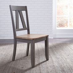 a wooden chair sitting on top of a carpeted floor next to a white brick wall