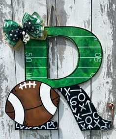 the letter d is made out of paper and has a football on it with a bow