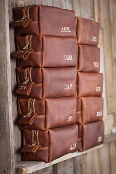 a stack of brown books sitting on top of a wooden shelf next to a wall