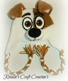 a crocheted hat with a dog's face on it and two hands