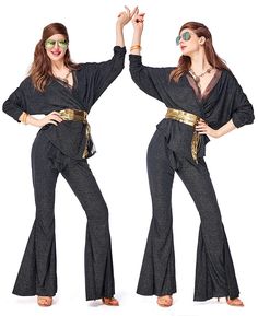 two women in black and gold outfits posing for the camera with their hands up while wearing sunglasses