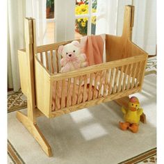 a teddy bear sitting in a wooden crib