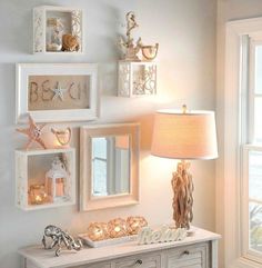 a white dresser sitting under a window next to a lamp