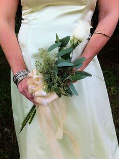 a woman in a white dress holding a bouquet of flowers