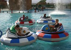 people are riding in bumper boats at the water park