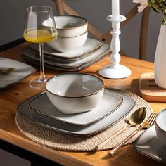 the table is set with silver and white dishes