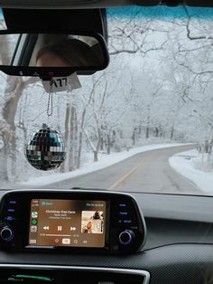 the dashboard of a car with a mirror ball hanging from it's dash board