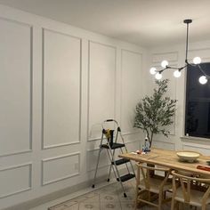 a dining room with white walls and wooden table