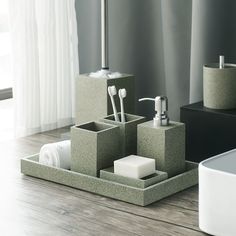 a bathroom set with soap, toothbrushes and tissue dispenser on a wooden table