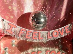 there is a disco ball on top of a table with the words i feel love spelled across it