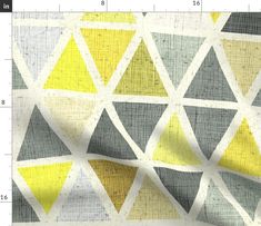 an orange, grey and white fabric with small triangles on the back ground is shown