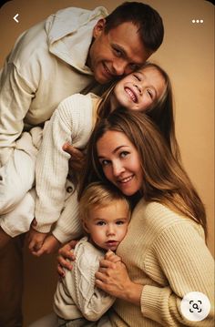 three adults and two children are posing for a family photo with their arms around each other