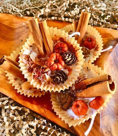 some food is sitting on a wooden platter with cinnamon sticks and other things around it