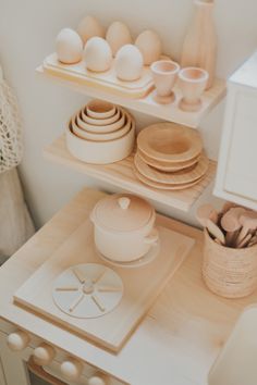 there are many plates and bowls on the shelves