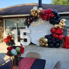 a table topped with balloons and flowers next to a sign that says number fifty five