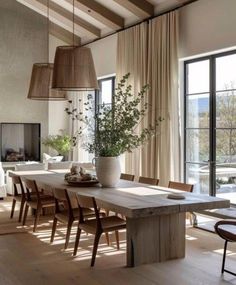 a dining room table and chairs in front of large windows with wooden beams on the ceiling