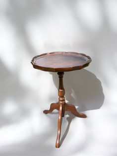 a small wooden table with one leg on it's end and the other foot on top