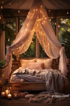 a canopy bed with lights hanging from it's sides and pillows on the floor