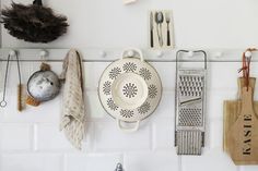 kitchen utensils hanging on the wall above a sink