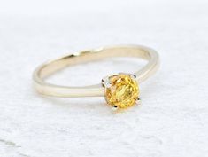 CERTIFIED Sapphire Ring set with a Natural Yellow Sapphire in a flawless diamond cut & yellow color, 0.65 Carats, 5mm round. The ring weighs 2.02 Grams of Solid 18k Gold. Premium Fine Jewellery ☞ made to last. Details: * Natural Yellow Sapphire: size 5mm, 0.65 Carat (CERTIFIED!) * Band Width 1.4 millimetres * Band Thickness 1.2 millimetres * Solid 18k White Gold ☞ 750 Hallmark * GUARANTEE on materials - GIL Certificate included ♕ * Premium Ring box included  *Sizes 12-16 U.S. need to be custom m Yellow Sapphire Ring Brilliant Cut Fine Jewelry, Yellow Brilliant Cut Sapphire Ring, Fine Jewelry Yellow Diamond Ring With Center Stone, Yellow Diamond Ring With Yellow Sapphire Gemstone, Yellow Sapphire Diamond Ring With Gemstone, Yellow Sapphire Diamond Ring For Wedding, Yellow Sapphire Ring With Center Stone In Yellow Gold, Yellow Sapphire Ring For Wedding, Anniversary Yellow Sapphire Ring Brilliant Cut