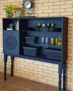 a black shelf with baskets on it next to a brick wall