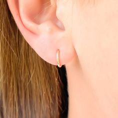 This pair of earrings is the smallest of our thick mini hoops. These are bold, yet subtle ear huggers. 7 mm diameter Made with 16 gauge wire 14K gold filled, 14K rose gold filled, and sterling silver End of hoop thinned out to 21 gauge to slip through ear, with a butterfly clutch Simple Hypoallergenic Yellow Gold Huggie Earrings, Simple Huggie Cartilage Single Earring, Simple Single Huggie Cartilage Earring, Minimalist Rose Gold Huggie Earrings, Tiny Hoop Huggie Earrings Minimalist Style, Minimalist Rose Gold Huggie Cartilage Earrings, Rose Gold 14k Gold Filled Huggie Earrings, Simple 14k Rose Gold Hoop Earrings, Everyday Minimalist Rose Gold Huggie Earrings