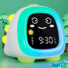 an alarm clock is sitting on the table next to some green and yellow decorations,