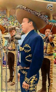 a man wearing a sombrero standing in front of microphones at a concert